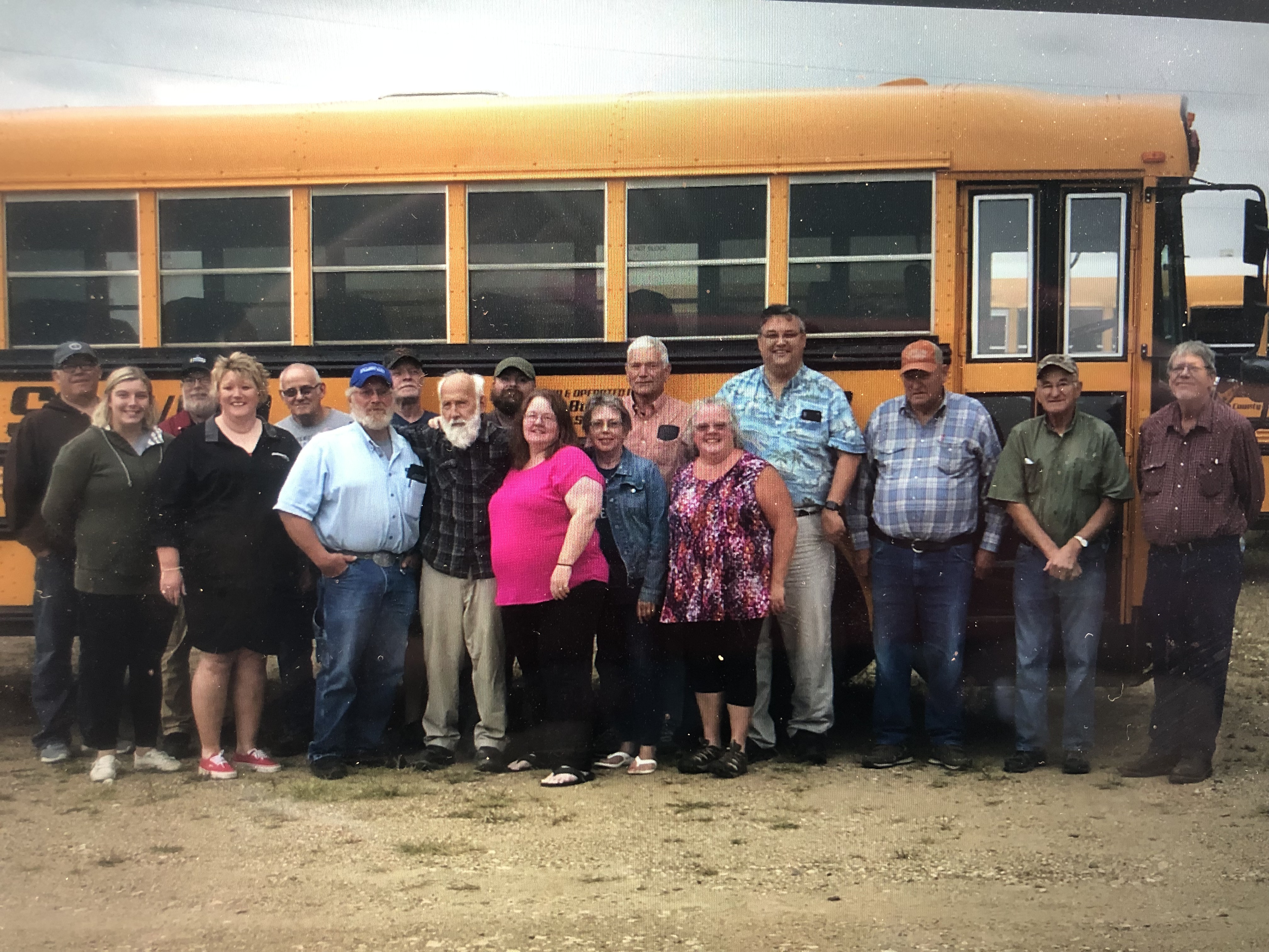 a group of 17 people in front of a bus